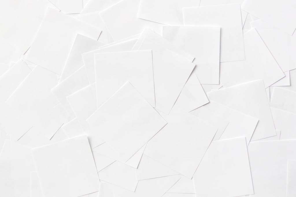 Overhead view of scattered white paper sheets creating an abstract pattern.