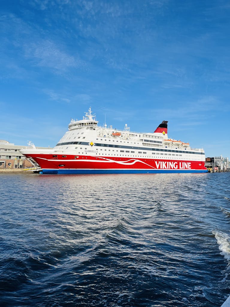 Bright red Viking Line ferry at a northern European port under a clear sky.