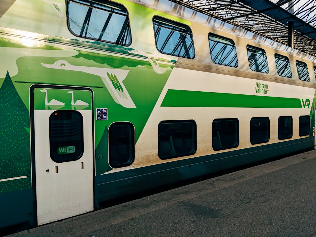 Colorful double-decker train at Helsinki's main station, Finland, showcasing eco-friendly design.